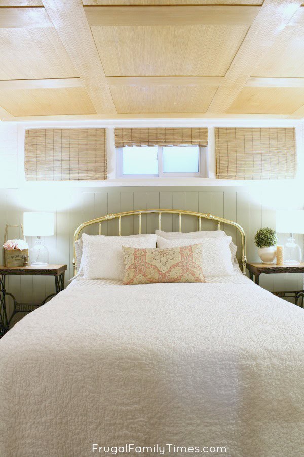 How to add vertical shiplap paneling in a way that's both easy and affordable! This sage green painted, vertical panelling was created on a tiny budget - less than $25 including the paint! (Behr's Milk Thistle) Basement bedroom: basement window covering, antique treadle sewing table, and more #decor #budgetdecor #bedroomideas #basement #farmhouse #cottage #frugalfamilytimes how to vertical shiplap