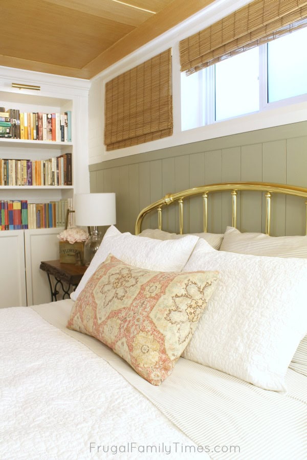 How to add vertical shiplap paneling in a way that's both easy and affordable! This sage green painted, vertical panelling was created on a tiny budget - less than $25 including the paint! (Behr's Milk Thistle) Basement bedroom: basement window covering, antique treadle sewing table, and more #decor #budgetdecor #bedroomideas #basement #farmhouse #cottage #frugalfamilytimes vertical shiplap walls diy