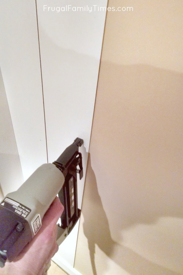 How to add vertical shiplap paneling in a way that's both easy and affordable! This sage green painted, vertical panelling was created on a tiny budget - less than $25 including the paint! (Behr's Milk Thistle) Basement bedroom: basement window covering, antique treadle sewing table, and more #decor #budgetdecor #bedroomideas #basement #farmhouse #cottage #frugalfamilytimes installing vertical shiplap